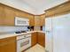 Kitchen features light wood cabinets and white appliances at 7405 Excitement Dr, Kissimmee, FL 34747