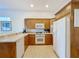 Kitchen features light wood cabinets, white appliances, and tile flooring at 7405 Excitement Dr, Kissimmee, FL 34747
