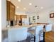 The kitchen includes a breakfast bar with white bar stools, wood cabinets, and stainless steel appliances at 7405 Excitement Dr, Kissimmee, FL 34747