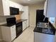 White kitchen cabinets, black appliances, and granite countertops at 1609 Little Falls Cir # 79, Orlando, FL 32807