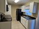 Kitchen with white cabinets, black appliances, and granite countertops at 1609 Little Falls Cir # 79, Orlando, FL 32807