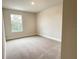 A carpeted bedroom with a window offering natural light and neutral-colored walls at 3037 Tackle Dr, Leesburg, FL 34748