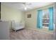 Bedroom with a white crib, neutral walls, and a window with blue curtains at 5578 Metrowest Blvd # 101, Orlando, FL 32811