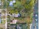 Aerial view of a private property with a pool, bordered by lush trees and a lake with personal docks at 1003 Oakdale St, Windermere, FL 34786