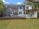 Home's back exterior features a screened pool, a covered patio, and lush landscaping at 1003 Oakdale St, Windermere, FL 34786