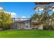 Spacious back exterior of home featuring a screened lanai, outdoor kitchen, and beautifully landscaped yard at 1003 Oakdale St, Windermere, FL 34786