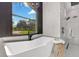 Bright bathroom features a soaking tub with a view and a glass-enclosed shower at 1003 Oakdale St, Windermere, FL 34786