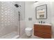 Elegant bathroom with a walk-in shower featuring decorative tile and a modern vanity with unique wood accents at 1003 Oakdale St, Windermere, FL 34786
