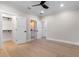 Spacious bedroom showcasing light hardwood floors, white trim, and access to an adjacent bathroom at 1003 Oakdale St, Windermere, FL 34786