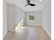 Inviting bedroom featuring light wood floors, a ceiling fan, and a window bringing in natural light at 1003 Oakdale St, Windermere, FL 34786