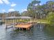 Exterior view of boat dock with covered structure, ladder, and bench for enjoying lake views at 1003 Oakdale St, Windermere, FL 34786
