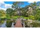 Beautiful lake view featuring a charming wooden dock with rope railings leading to the water and lush greenery at 1003 Oakdale St, Windermere, FL 34786