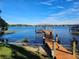 Dock on the lake with a covered sitting area, sandy shoreline, and clear blue skies at 1003 Oakdale St, Windermere, FL 34786