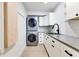 Bright laundry room with white cabinets, granite countertops, and modern appliances at 1003 Oakdale St, Windermere, FL 34786