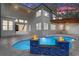 Beautiful outdoor living space with pool, fire features, outdoor kitchen, and covered seating area at 1003 Oakdale St, Windermere, FL 34786