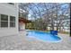 Screened pool features stone surround, water feature, and a covered outdoor area at 1003 Oakdale St, Windermere, FL 34786