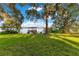 Scenic waterfront property showcasing a lush lawn leading to a lake with private dock and gazebo structures at 1003 Oakdale St, Windermere, FL 34786