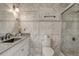 Updated bathroom with marble tiling, a glass shower, granite counters, and modern fixtures at 3260 Se 32Nd Ct, Ocala, FL 34471
