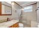 Updated bathroom features granite countertops and a tiled glass shower with a built-in bench at 3260 Se 32Nd Ct, Ocala, FL 34471