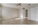 Bedroom with wood-look flooring, a ceiling fan, a closet, and an adjoining doorway at 3260 Se 32Nd Ct, Ocala, FL 34471