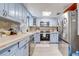 Stylish kitchen featuring light blue cabinets and stainless steel appliances at 3260 Se 32Nd Ct, Ocala, FL 34471