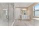 Modern bathroom with a glass-enclosed shower, white cabinets, and a bright window at 1209 Cresswind Blvd, Deland, FL 32724