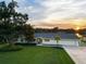 Light blue single story home with a gray roof, palm trees, and a sunset view at 3870 W Stillwood Ln, Lake Mary, FL 32746