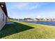 Lush green backyard with a view of the lake, complemented by a cozy patio area at 4363 Summer Breeze Way, Kissimmee, FL 34744