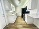 Bright kitchen with white cabinets, modern black appliances, and lovely wood-look floors at 1234 Sago Palm Blvd # 1234, Kissimmee, FL 34741