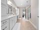 Luxurious bathroom featuring double sinks, granite counters, updated cabinets, an open shower, and tile flooring at 13333 Oakenshaw Ln, Orlando, FL 32832