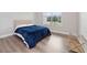 Simple bedroom with hardwood floors, a queen bed with blue covers, a window and an overhead light at 13333 Oakenshaw Ln, Orlando, FL 32832