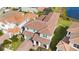 Aerial view of a two-story home featuring a clay tile roof, lush landscaping, and a two-car garage at 13333 Oakenshaw Ln, Orlando, FL 32832