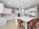 Bright kitchen with an island with counter seating, stainless appliances, and custom white cabinetry at 13333 Oakenshaw Ln, Orlando, FL 32832