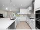 Bright kitchen features white cabinets, stainless appliances, an island with sink, and an open view to the living area at 13333 Oakenshaw Ln, Orlando, FL 32832
