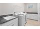 Functional laundry room with granite counters, sink, white cabinets, window and newer model washer and dryer at 13333 Oakenshaw Ln, Orlando, FL 32832