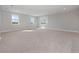 Expansive living room with neutral carpeting and an abundance of natural light streaming through large windows at 13333 Oakenshaw Ln, Orlando, FL 32832