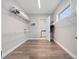 View of a walk-in closet, looking toward a laundry room. Has wooden laminate floors and shelving for storage at 13333 Oakenshaw Ln, Orlando, FL 32832