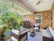 Relaxing covered patio with brick wall, comfortable seating, and lush greenery at 548 Coral Trace Blvd, Edgewater, FL 32132