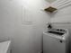 Bright laundry room featuring a white washing machine and wire shelving for storage at 5929 Windhover Dr # A02, Orlando, FL 32819