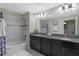 Bathroom featuring a double vanity, tub with tiled walls, and decorative accents at 1574 Slice Way, Davenport, FL 33896