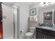 Bathroom with tiled shower, toilet, and vanity with framed artwork at 1574 Slice Way, Davenport, FL 33896
