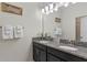 Bathroom featuring a double sink vanity with granite countertop and decorative accents at 1574 Slice Way, Davenport, FL 33896