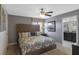 Bedroom featuring a large upholstered bed, ceiling fan, and ensuite bathroom access at 1574 Slice Way, Davenport, FL 33896
