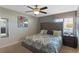 Bedroom featuring a plush upholstered bed, a ceiling fan, and a view of the ensuite bathroom at 1574 Slice Way, Davenport, FL 33896