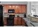 Modern kitchen with dark wood cabinets, granite counters, and black appliances at 904 Charo Pkwy # 536, Davenport, FL 33897