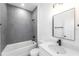 Modern bathroom with gray tile, white vanity, and bathtub at 2416 Sw 158Th Pl, Ocala, FL 34473