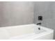 Close-up view of a white bathtub with gray tile surround at 2416 Sw 158Th Pl, Ocala, FL 34473