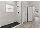 Modern bathroom featuring a glass-enclosed shower with white tile and a black honeycomb-tiled floor at 4513 Sw 170Th Rd, Ocala, FL 34473