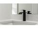 Close-up of a bathroom sink with modern black faucet and a white countertop with subtle stone specks at 4513 Sw 170Th Rd, Ocala, FL 34473
