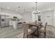 Open dining area with a modern chandelier, table setting, and a view into the contemporary kitchen at 4513 Sw 170Th Rd, Ocala, FL 34473